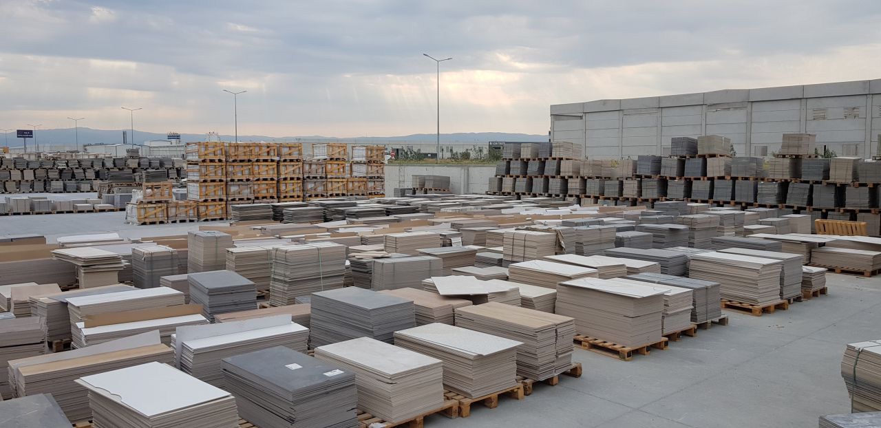 Assorted clearance tiles displayed on warehouse pallet including stone and porcelain styles