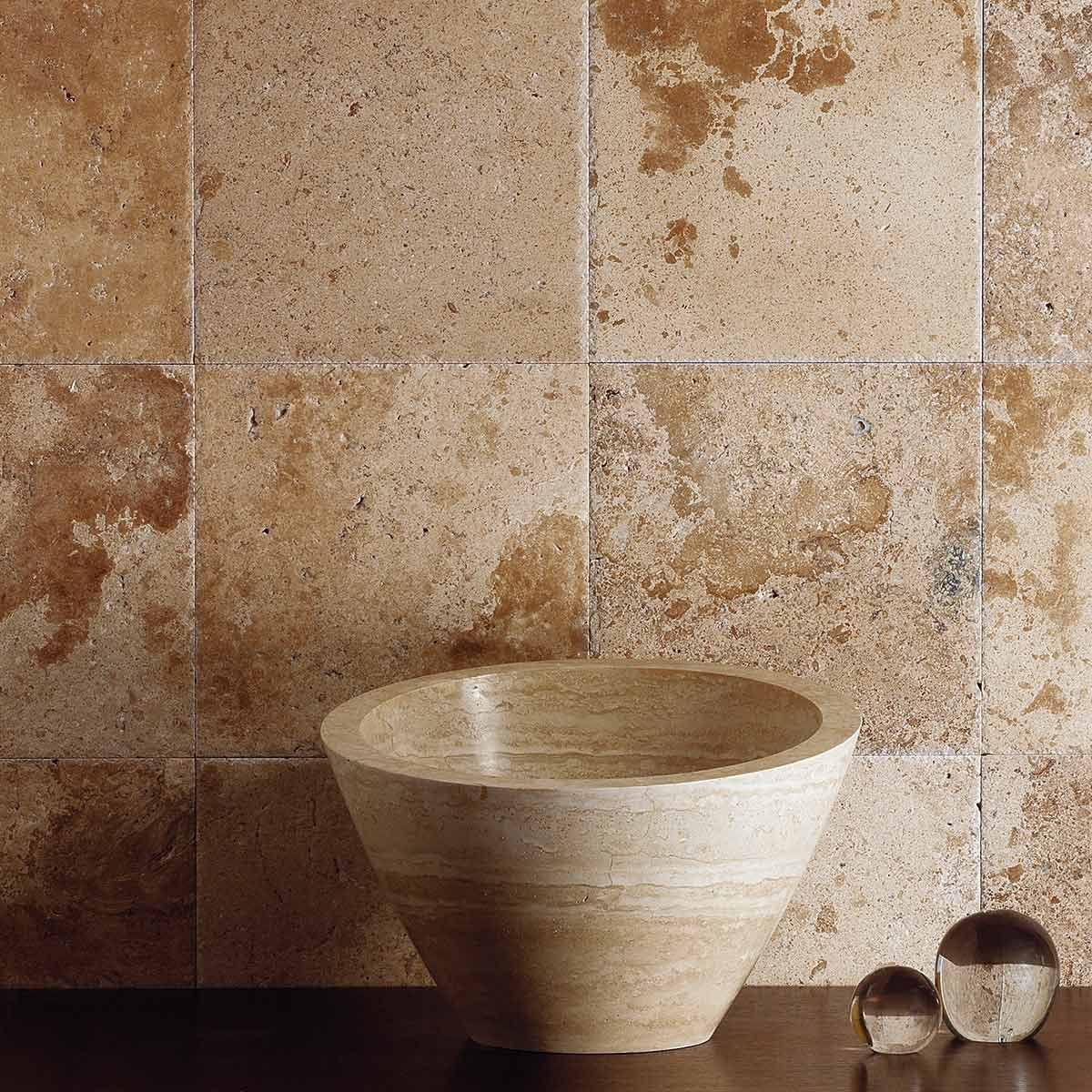 Limestone tile surface featuring natural earth tones, installed on a bathroom wall