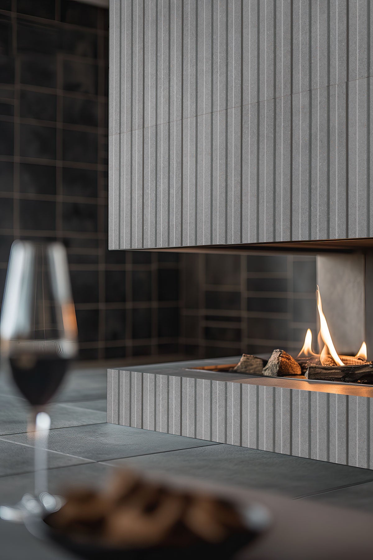 Sinfonia Hip Hop Ceniza Fluted Tiles installed on modern fireplace wall with seamless, elegant finish