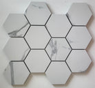 Flat lay of Calacatta Hexagon Porcelain Mosaic sheet with 3-inch marble-look tiles in gray and whit