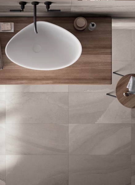 Flat lay of Fluido Bronzo 16x32 porcelain tile in warm bronze sandstone look.