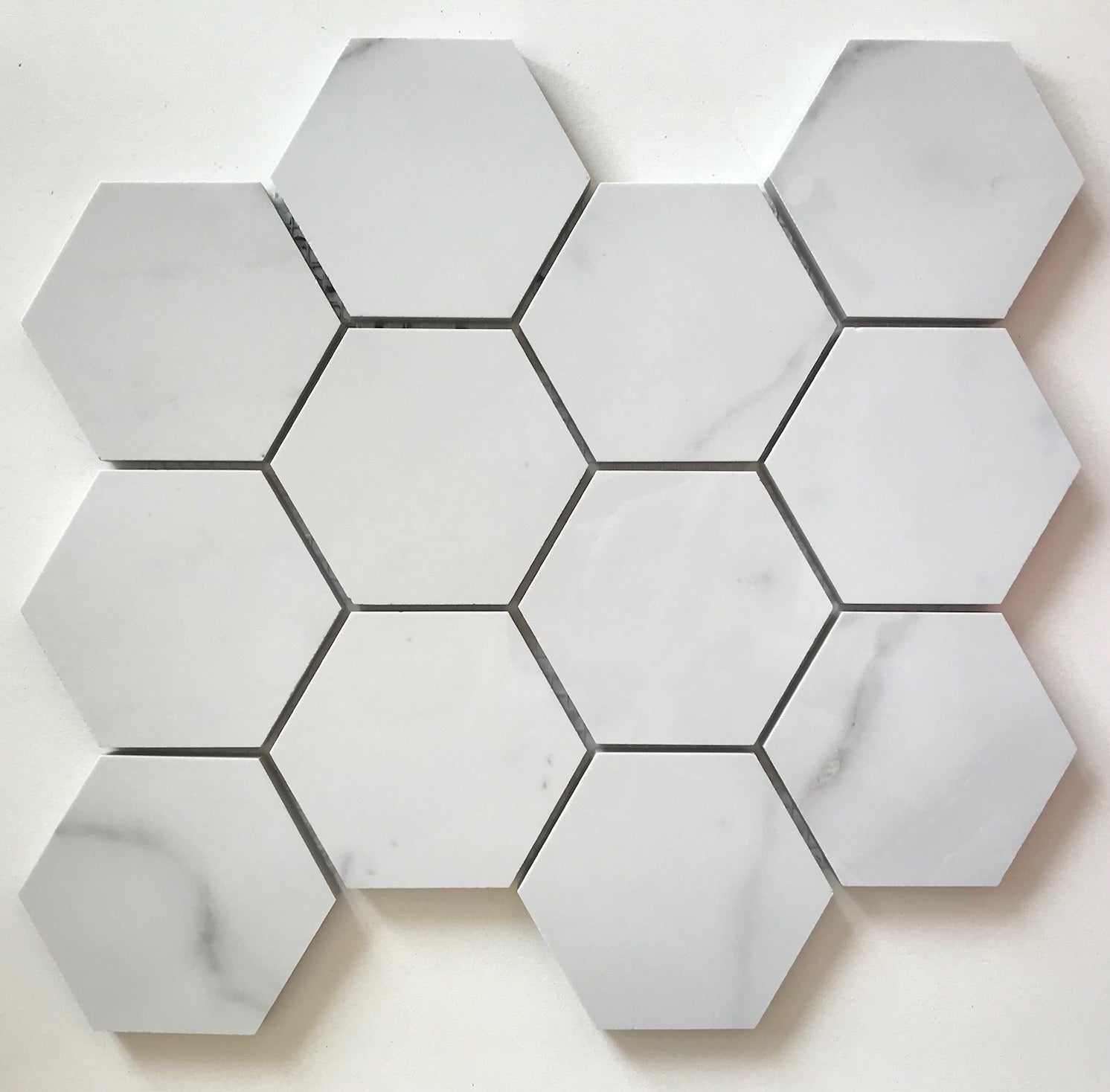 Flat view of Statuario Hexagon Mix Porcelain Mosaic with 3-inch gray and white marble-look tiles