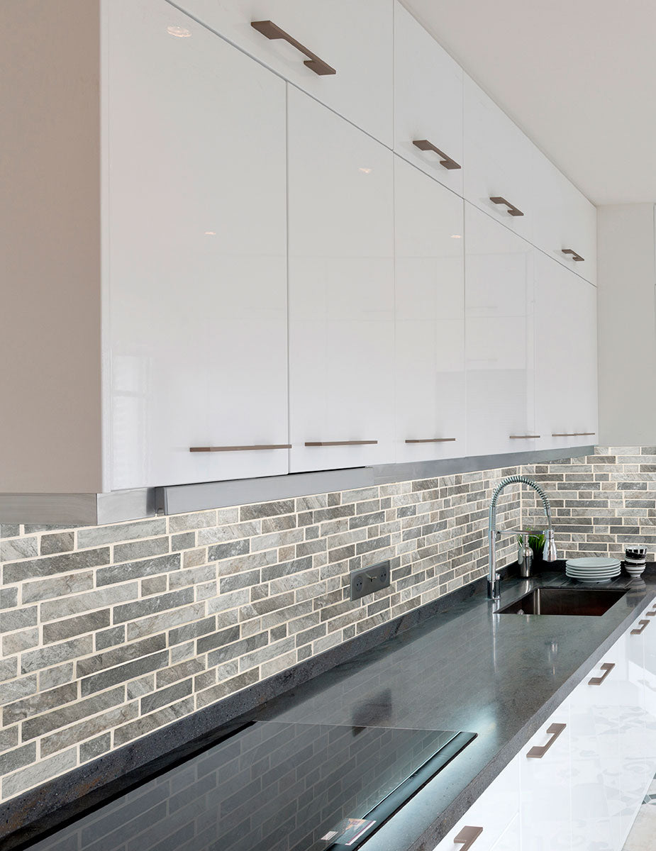 Close-up of Stonella Mosaic showing interlocking linear strips in gray, cream, and brown