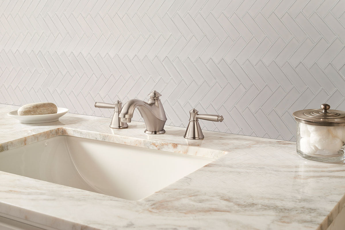 Close-up of porcelain herringbone pattern tiles showing glossy surface and beveled edges