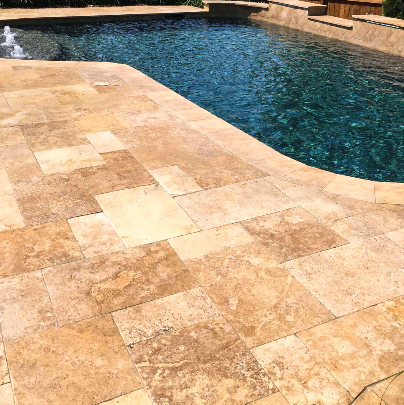 Installed Noce Travertine tile showing dark brown tones in a tumbled finish