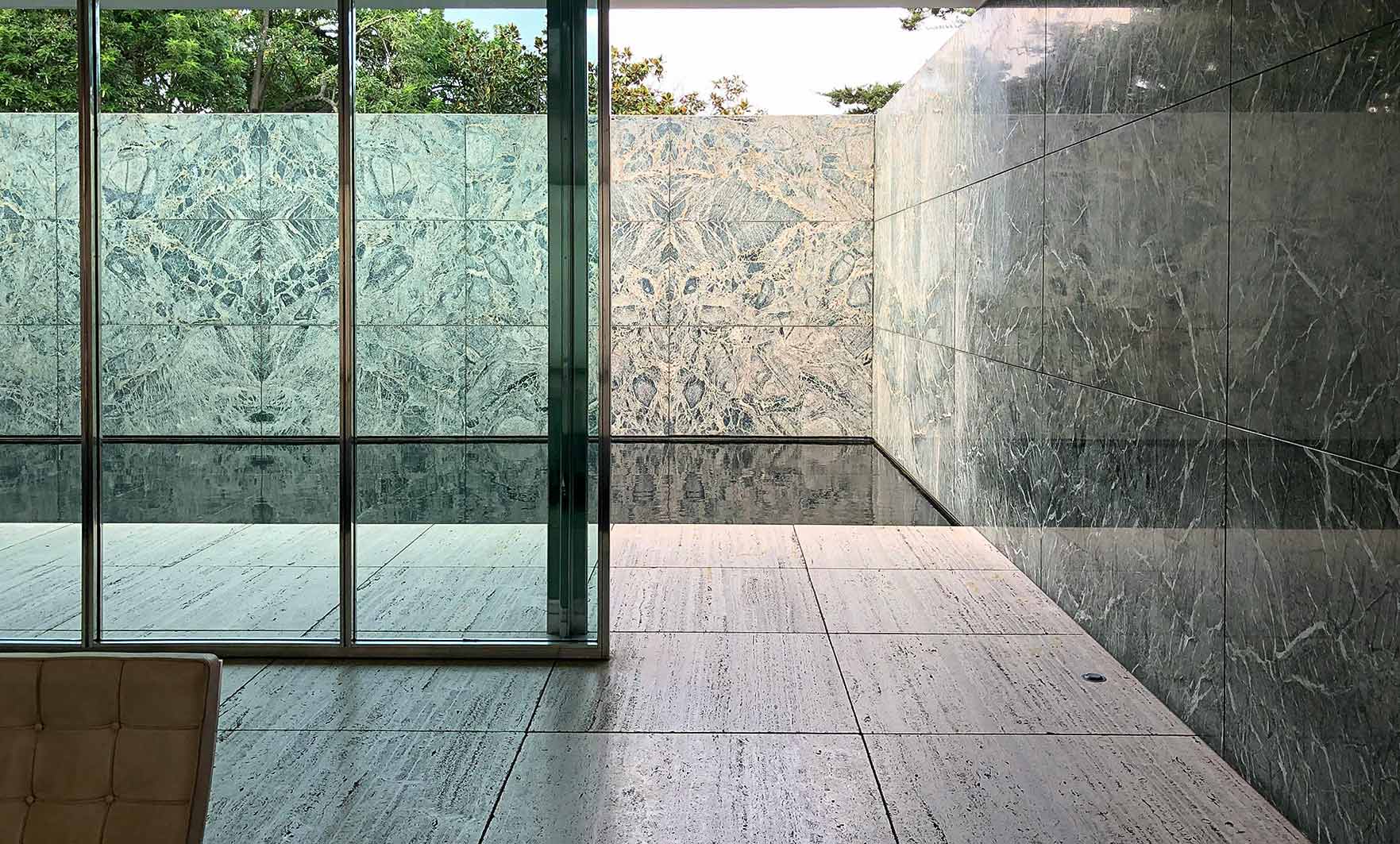 Assorted natural stone tiles in travertine, marble, and limestone, displayed in a grid with varying finishes and earthy tones