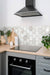 Arabescato Venato White hexagon tile installed as a backsplash in a modern kitchen.