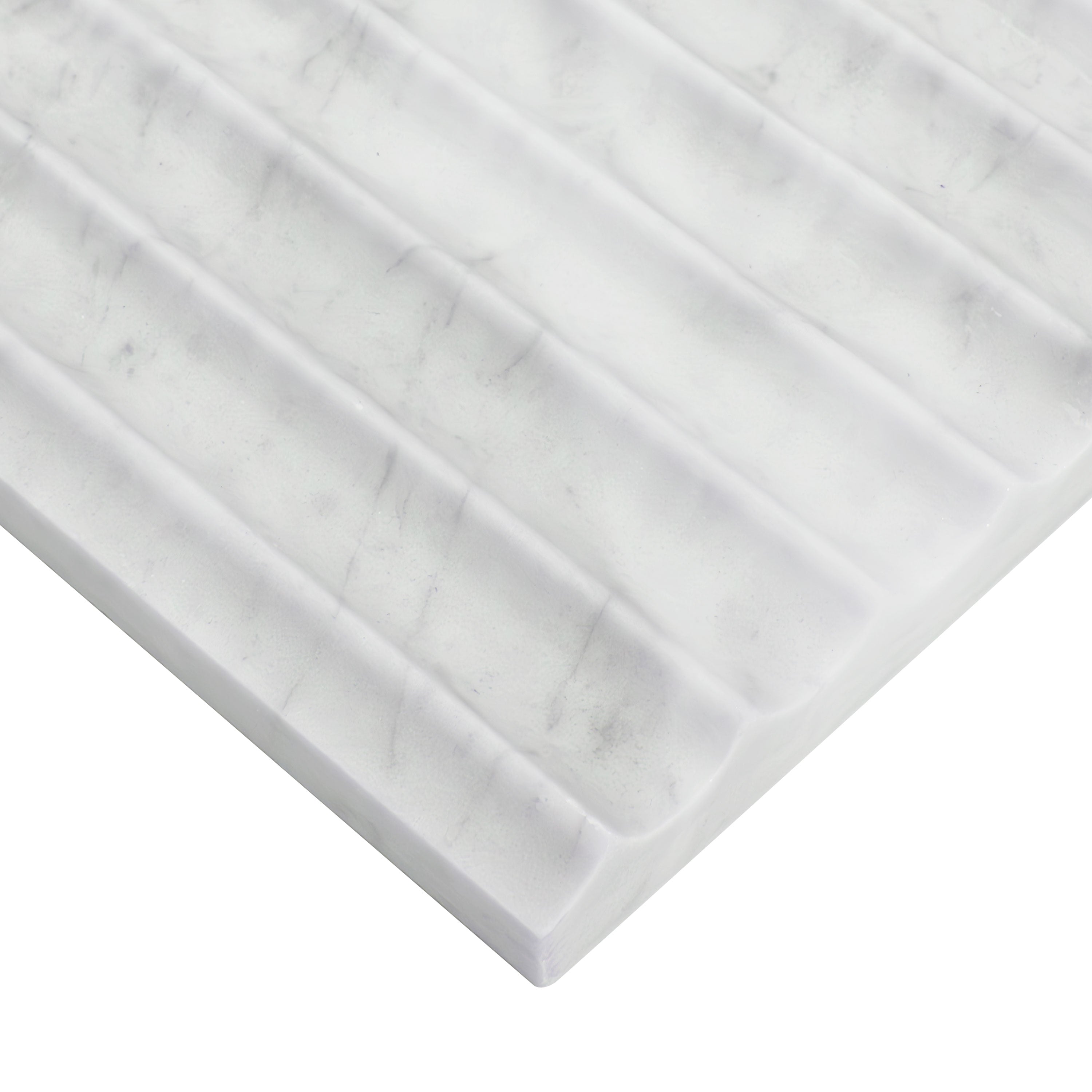 Edge of Carrara White marble showing inverted fluted surface and soft gray veining