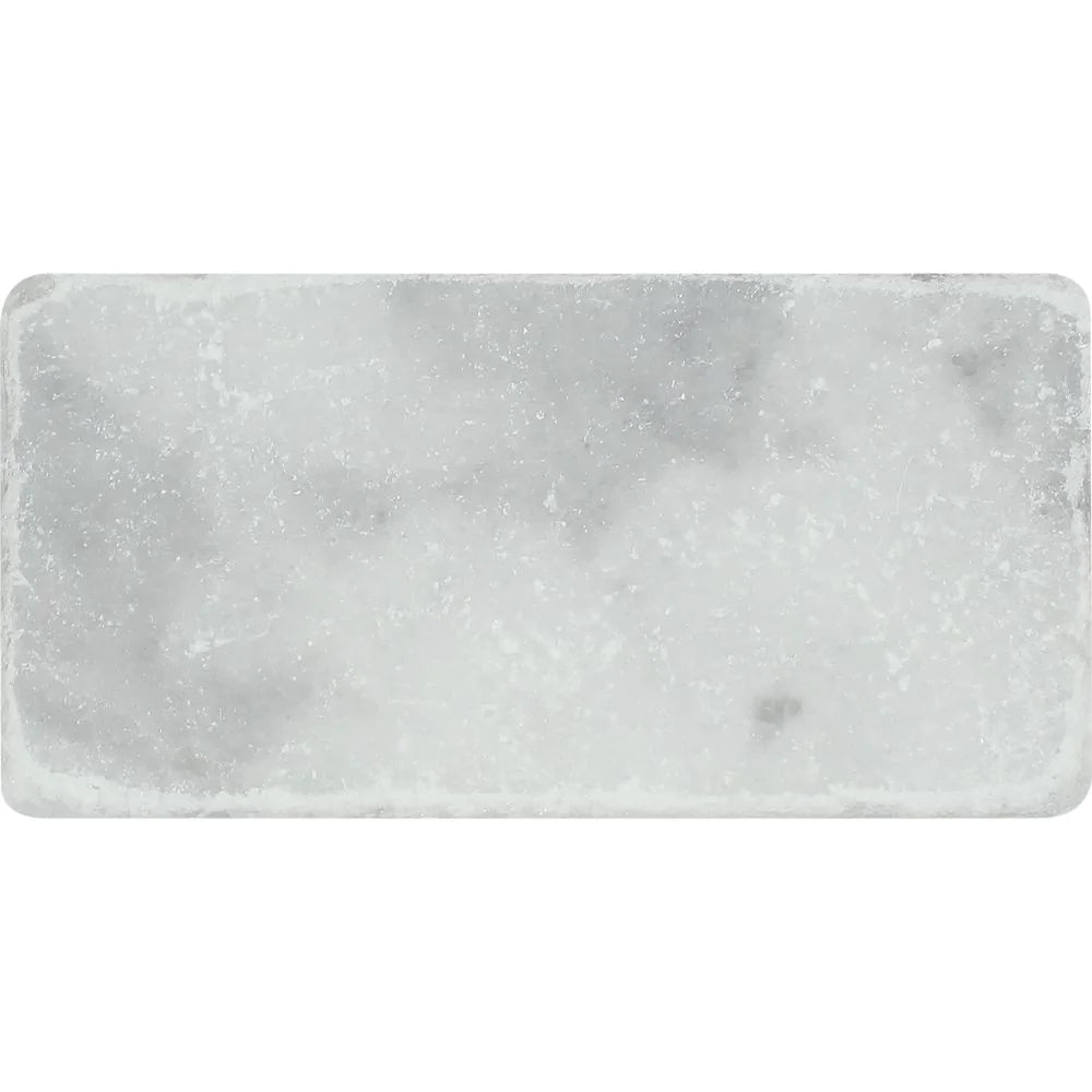 Close-up of Bianco Mare marble tile showing soft veining and tumbled edges