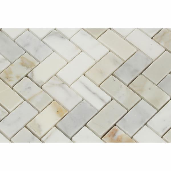 Close-up of Calacatta Gold 1x2 herringbone tile showing fine veining and interlock pattern