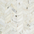 Close-up of Calacatta Gold marble in chevron layout with gold and gray veining