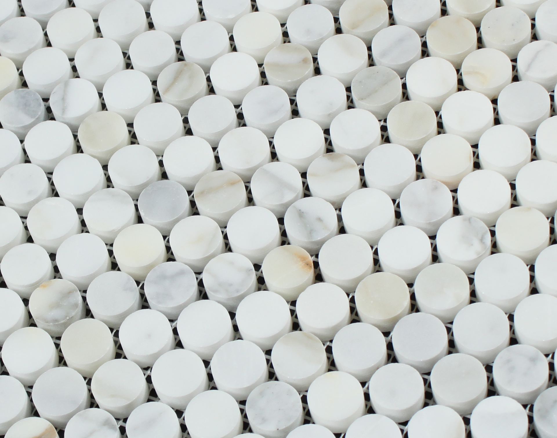 Close-up of Calacatta Gold marble penny rounds showing golden veining