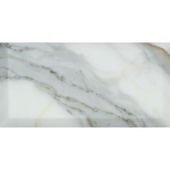 Close-up of 3x6 Calacatta Gold tile with beveled edge and veining details