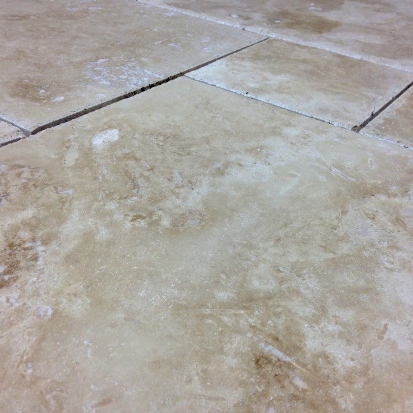 Close-up of Crema Ivory Travertine showing chiseled edge and soft textured surface