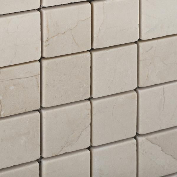 Close-up of Crema Marfil 2x2 mosaic with tumbled marble texture