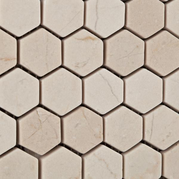 Close-up of tumbled 1 inch Crema Marfil marble hexagon mosaic