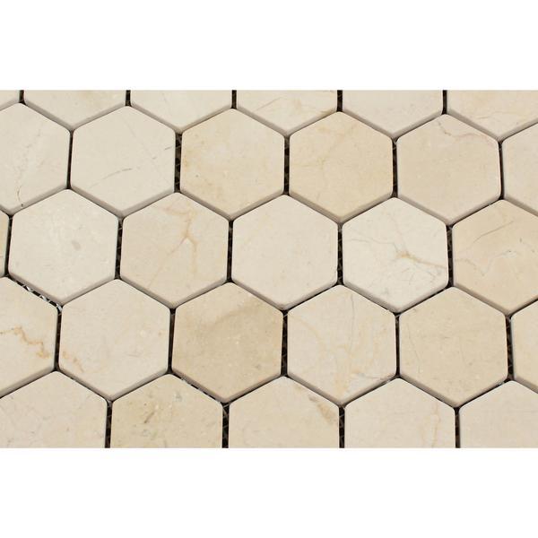 Close-up of tumbled 2x2 Crema Marfil marble hexagon tiles with natural veining