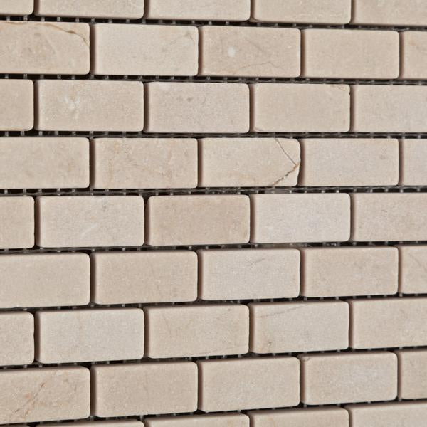 Close-up view of tumbled Crema Marfil Mini Brick marble mosaic