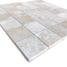 Close-up of 2x2 travertine tile showing honed texture and warm tones

