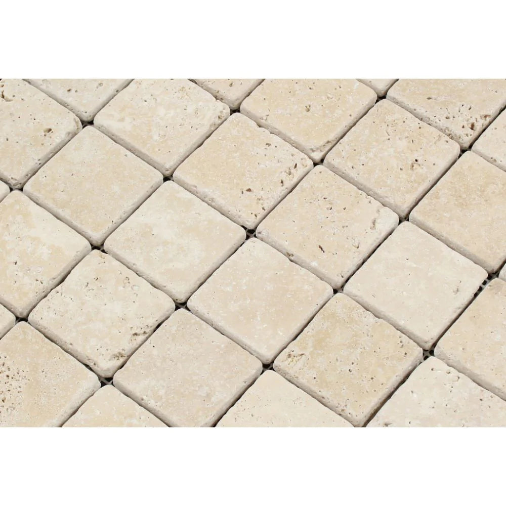 Close-up of Ivory Travertine 2x2 tiles showing textured tumbled finish