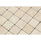 Close-up of Ivory Travertine 2x2 tiles showing textured tumbled finish