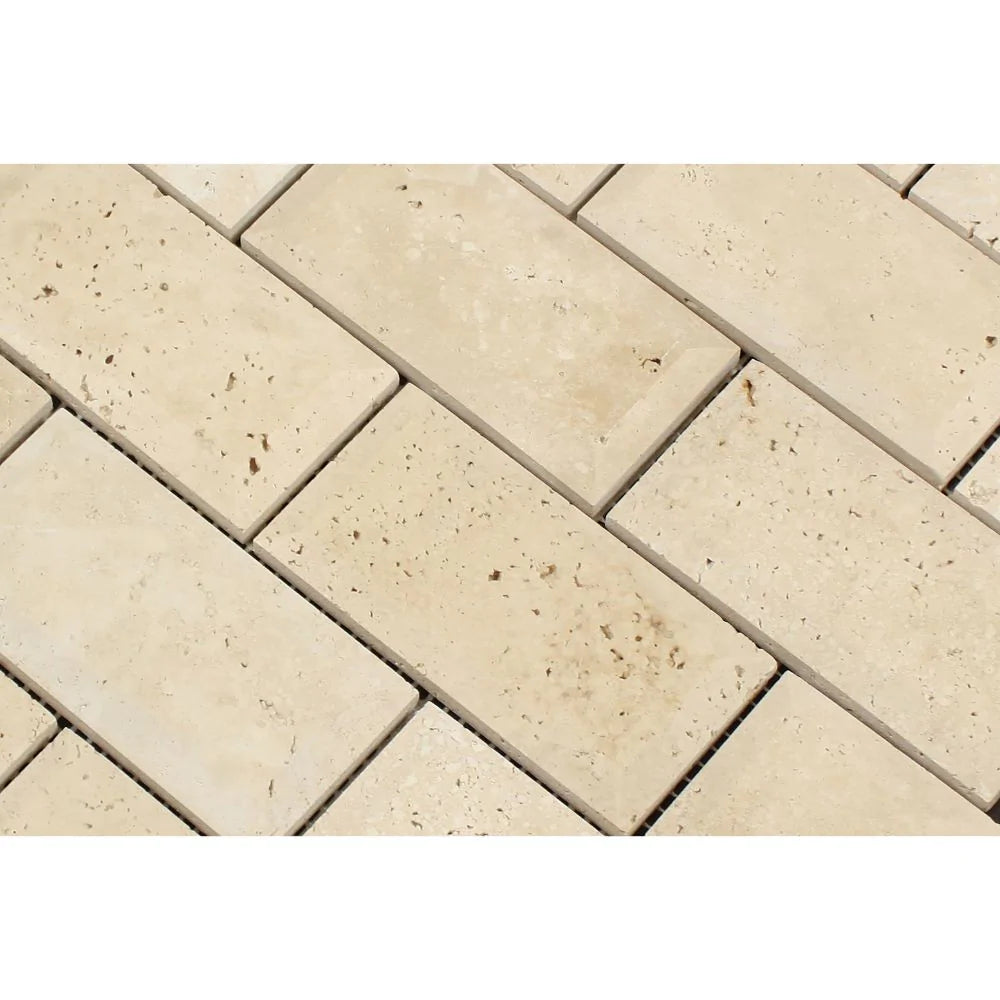 Close-up of Ivory Travertine 2x4 tiles showing deep bevel and warm tones