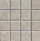 Close-up of Ivory Travertine 4x4 tile showing bevel depth and honed surface