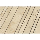 Close-up of random strip travertine mosaic showing cream and tan tones with honed finish
