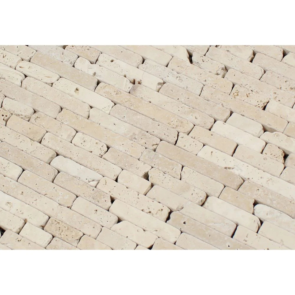 Close-up of tumbled travertine random strip mosaic showing varied lengths