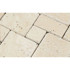 Close-up of tumbled travertine Opus pattern mosaic in ivory and beige