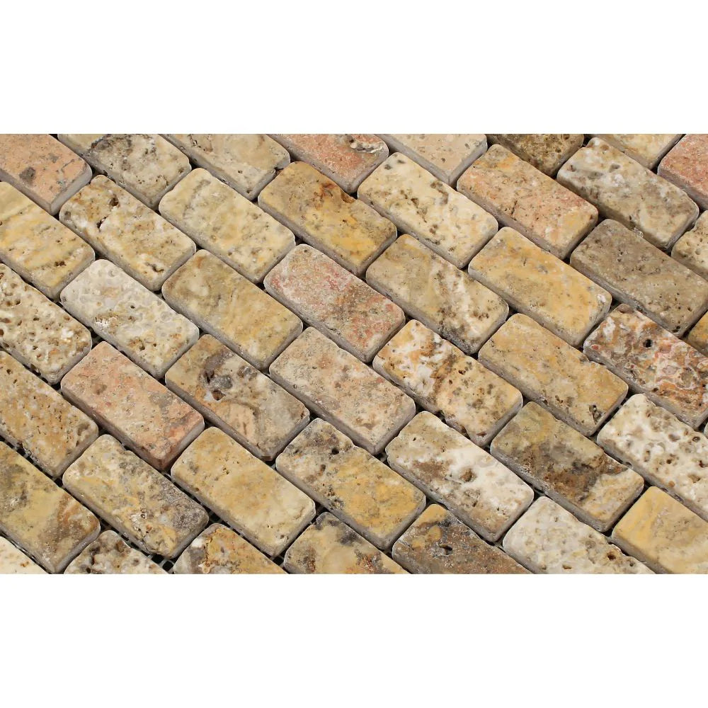 Detail of 1x2 tumbled travertine in warm red, gold, and gray hues