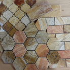 Close-up view of 2x2 tumbled Scabos Travertine showing rich red, gold, and cream colors