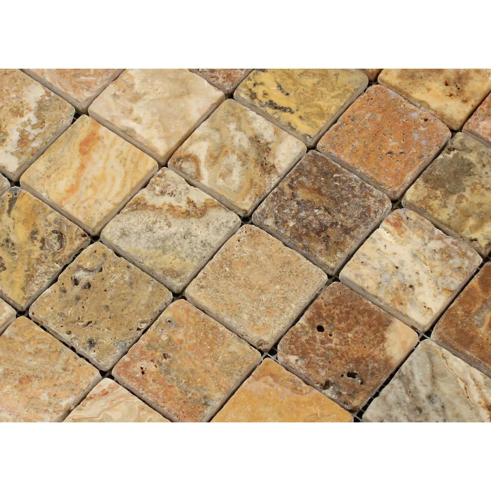 Close-up view of 2x2 tumbled Scabos Travertine showing rich red, gold, and cream colors