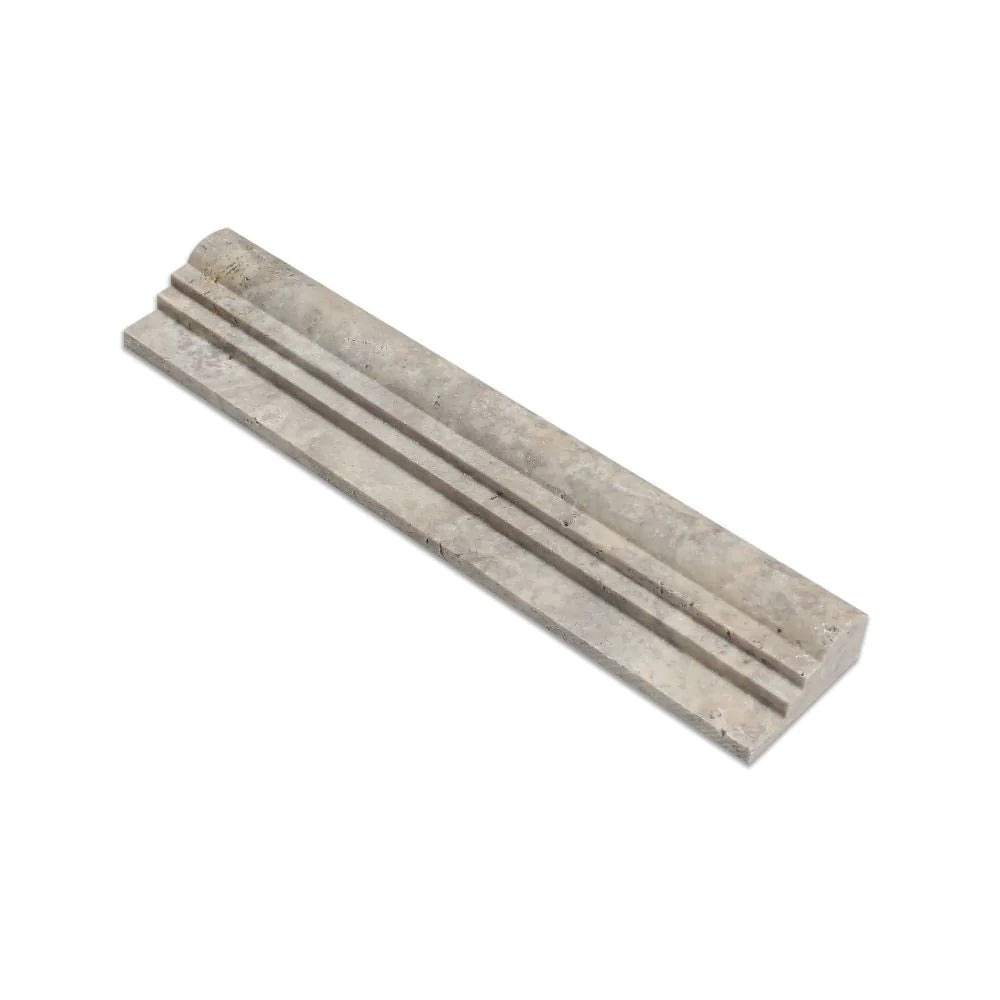 Close-up of OG2 molding profile showing double-step edge and honed surface in silver travertine