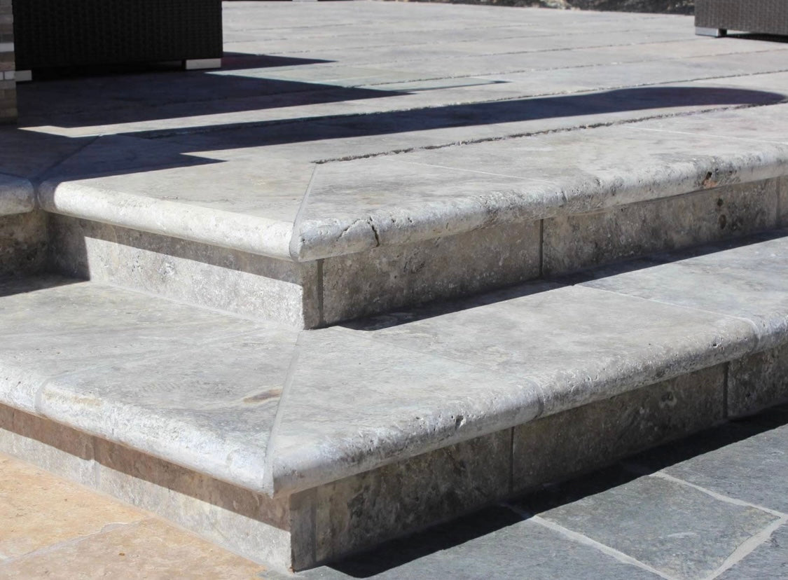 Silver Travertine Pool Coping installed on pool edge with coordinating pavers