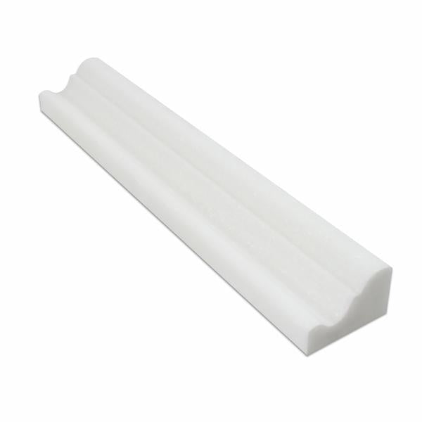 Close-up of Thassos White marble crown molding showing polished surface and edge profile