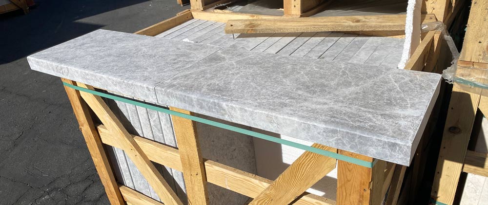 Close-up of modern edge profile and veining in Tundra Grey marble coping