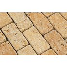 Close-up of Tuscany Gold 2x4 travertine mosaic showing rustic texture and tumbled edges