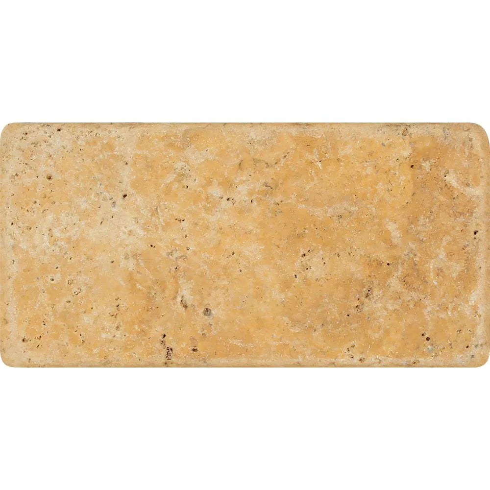 Close-up of Tuscany Gold 3x6 tile with tumbled finish and natural stone texture