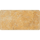 Close-up of Tuscany Gold 3x6 tile with tumbled finish and natural stone texture