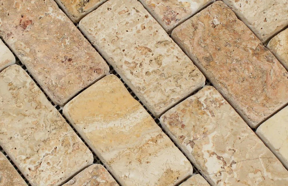 Close-up of Valencia Travertine 2x4 mosaic showing natural texture and variation in cream, rust, and red tones