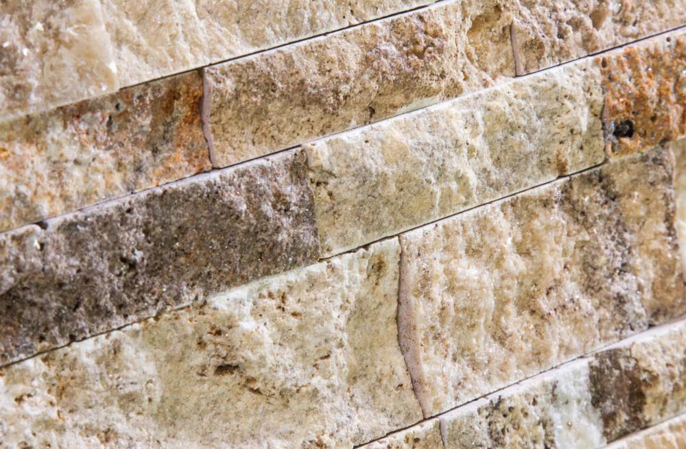 Close-up of chiseled Valencia Travertine ledger panel with cream and rust tones
