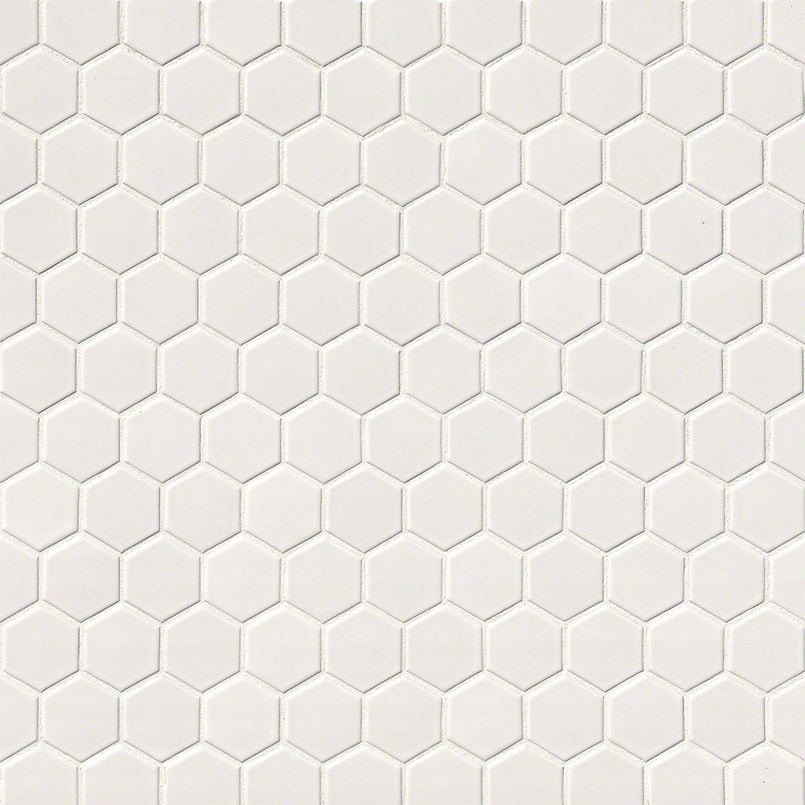 Close-up of glossy 2-inch porcelain hex tiles with soft cream tone and clean grout spacing